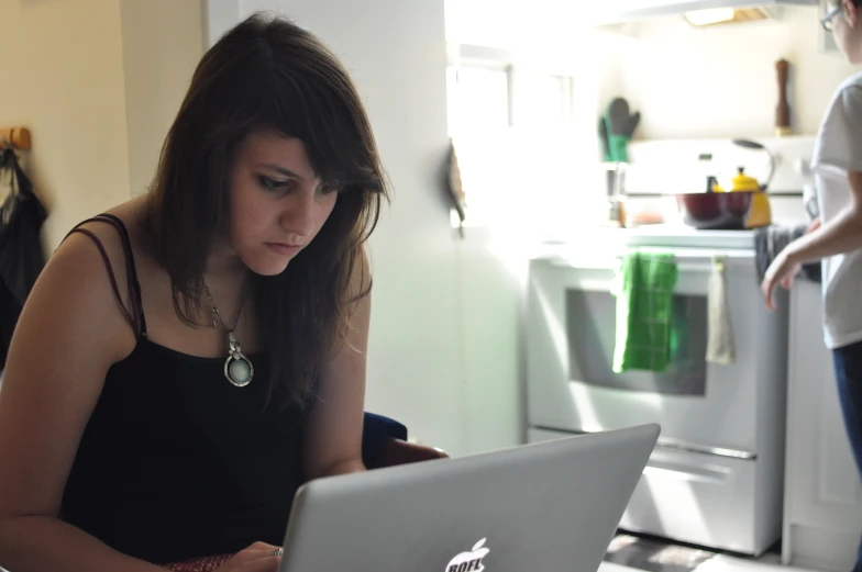 a woman sitting in front of a laptop computer