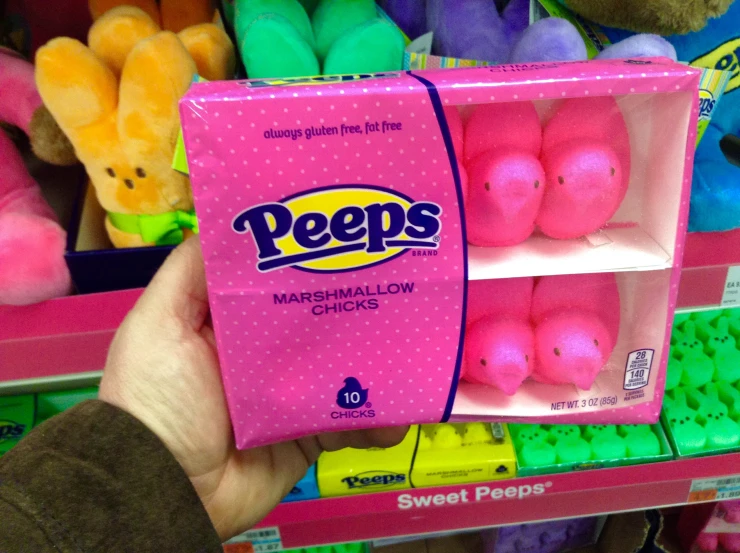a hand holding a box of peeps marshmallow chicks