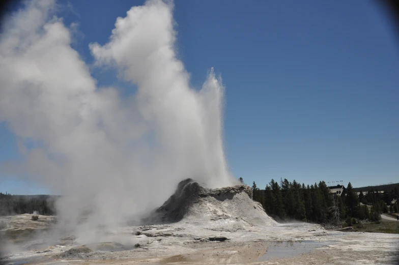 a geyser spewing water out of a pool of steam