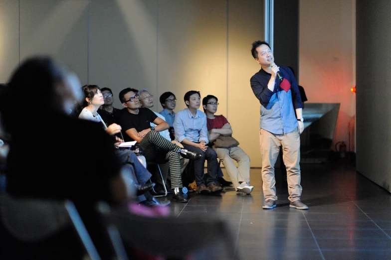 a man on stage with audience in the background