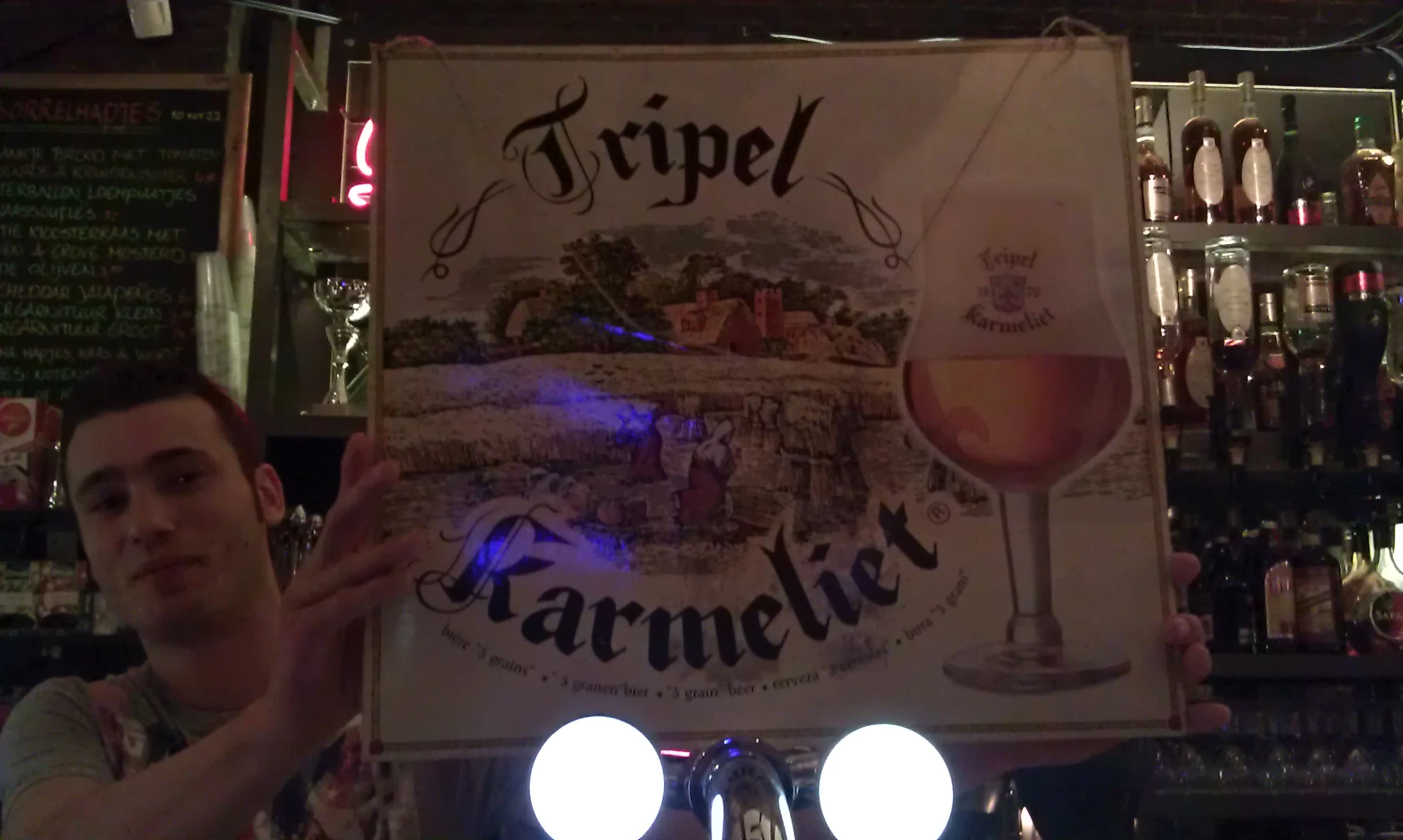 a man holding up a lit sign with an image of a wine glass