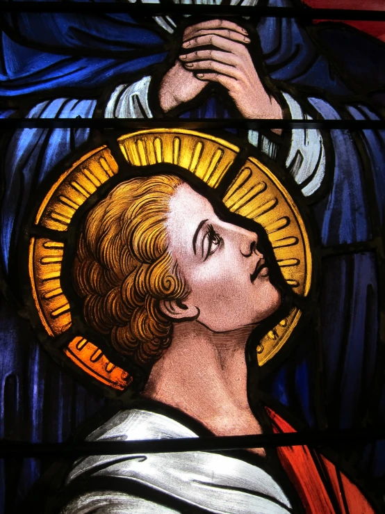 the stained glass has a man holding a cross