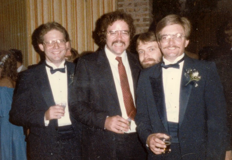 three men posing for a po together wearing suits and ties