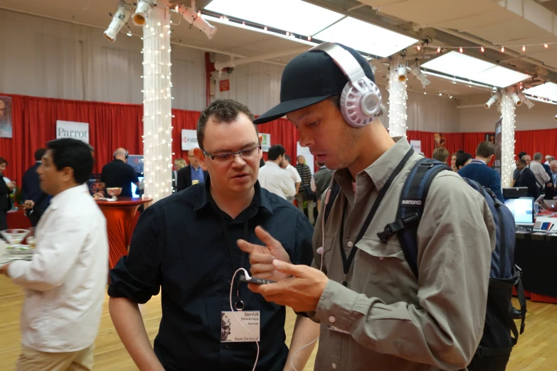 two men talk while having a conversation at an event