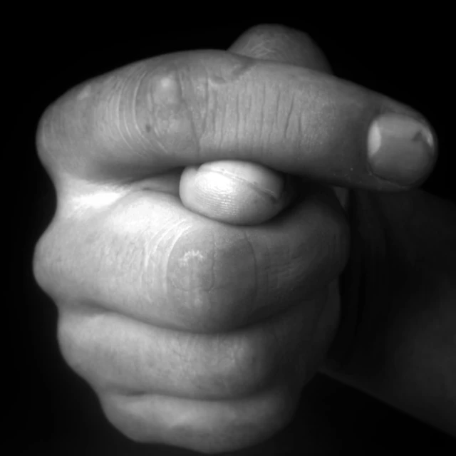 black and white pograph of a person's hand pointing towards the camera