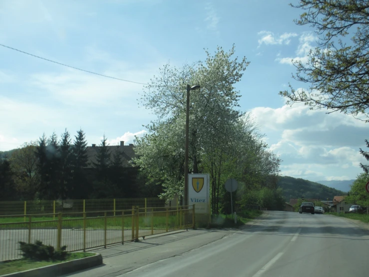 a paved road with a small yellow fence