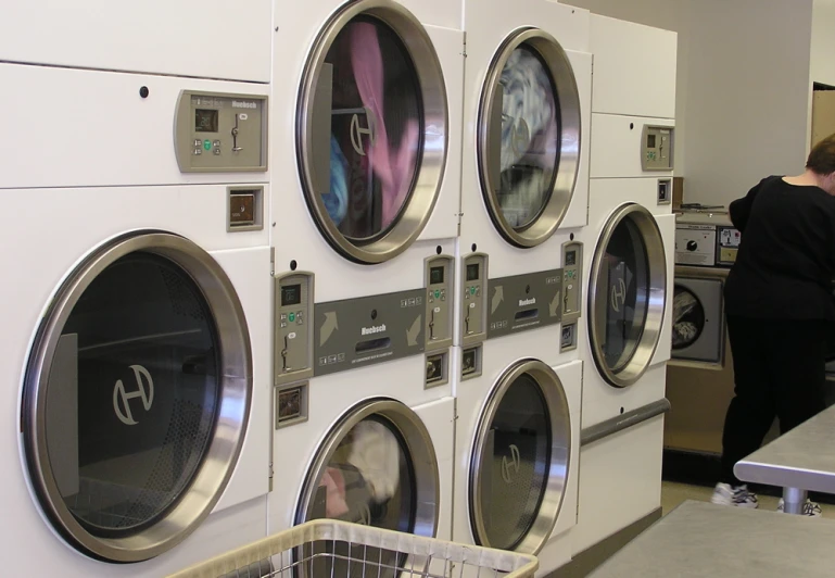 a woman and her baby stand near an assortment of machines