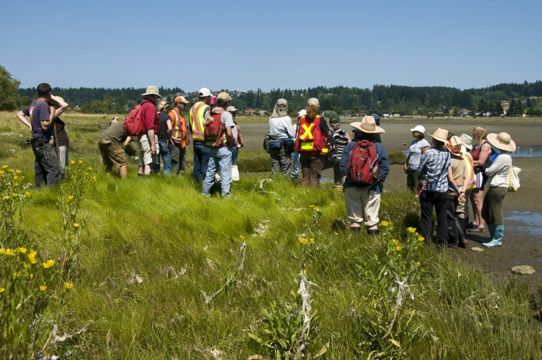 a group of hikers standing near the edge of a lake