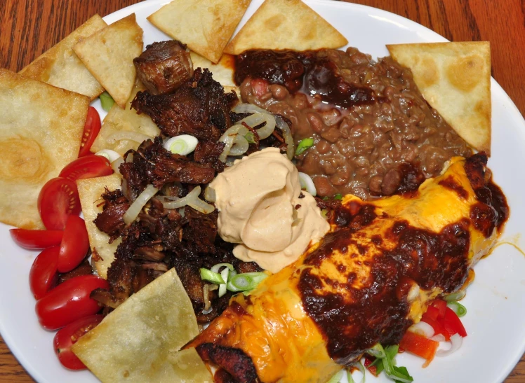 a plate filled with taco meat and tortilla chips