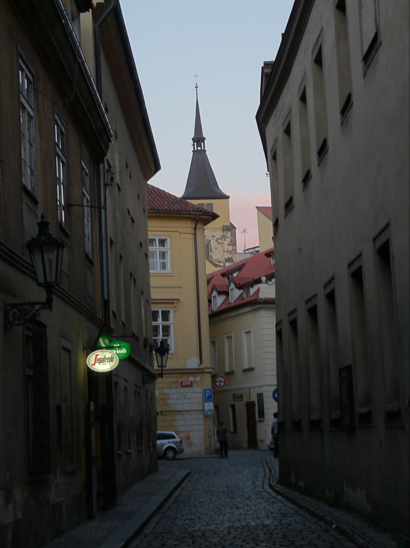 an alley way lined with old buildings and clock tower