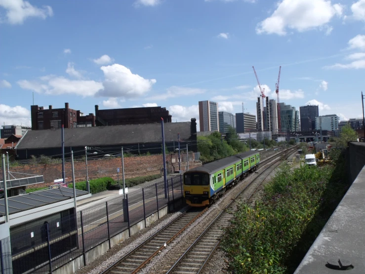 a train driving down tracks past tall buildings