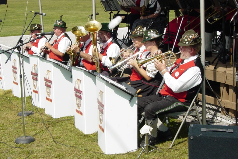 men in marching uniforms, playing musical instruments on a wall