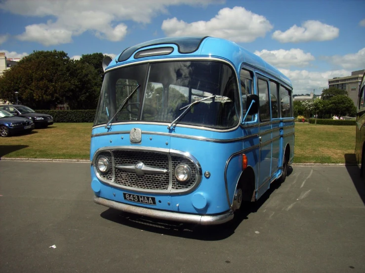 an old, blue bus is parked in a parking lot