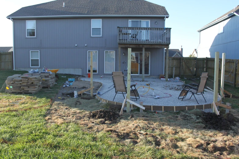 several lawn chairs outside of a small backyard setting