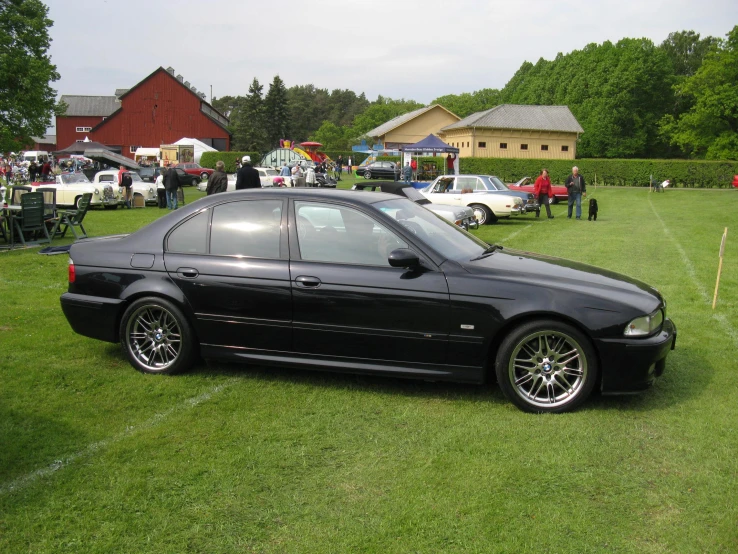 a black sports car sits in a grassy area