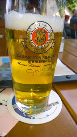 a large glass of beer sitting on top of a table