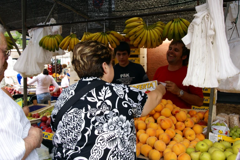 a woman is shopping for produce at a local market