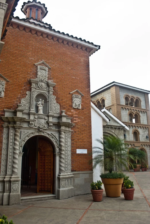 the building has two small archways and potted plants