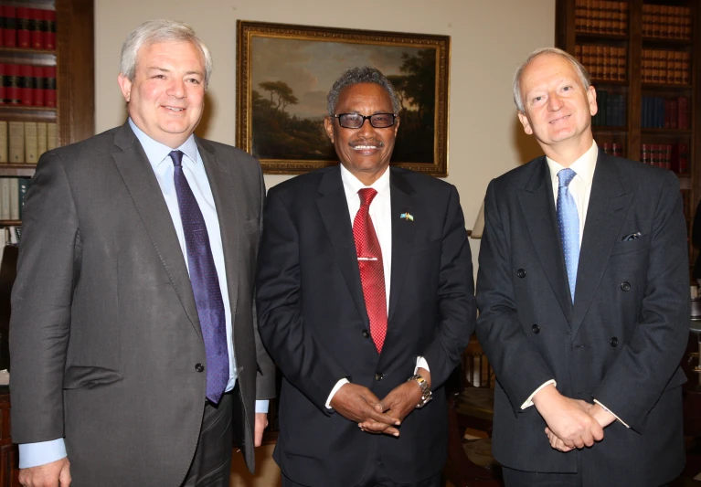 three men posing for the camera in suits