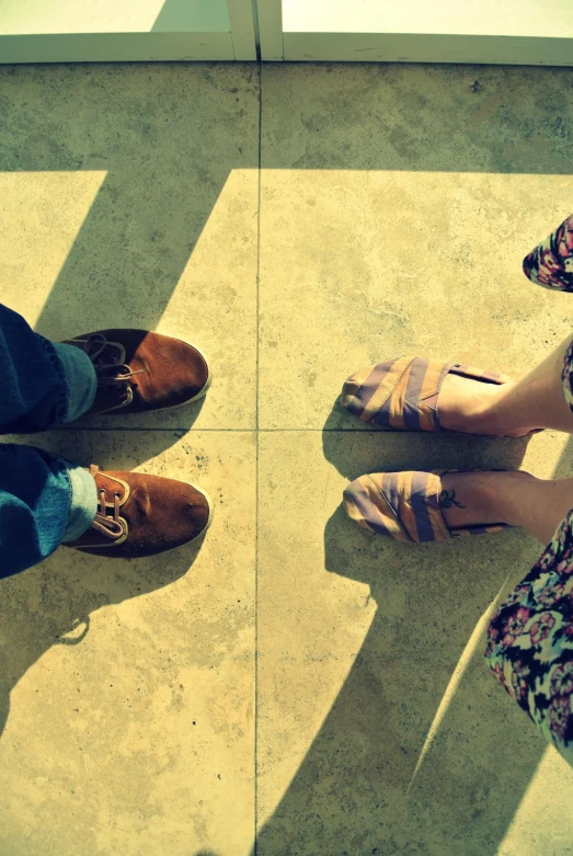 two people standing on a tile floor with a glass panel