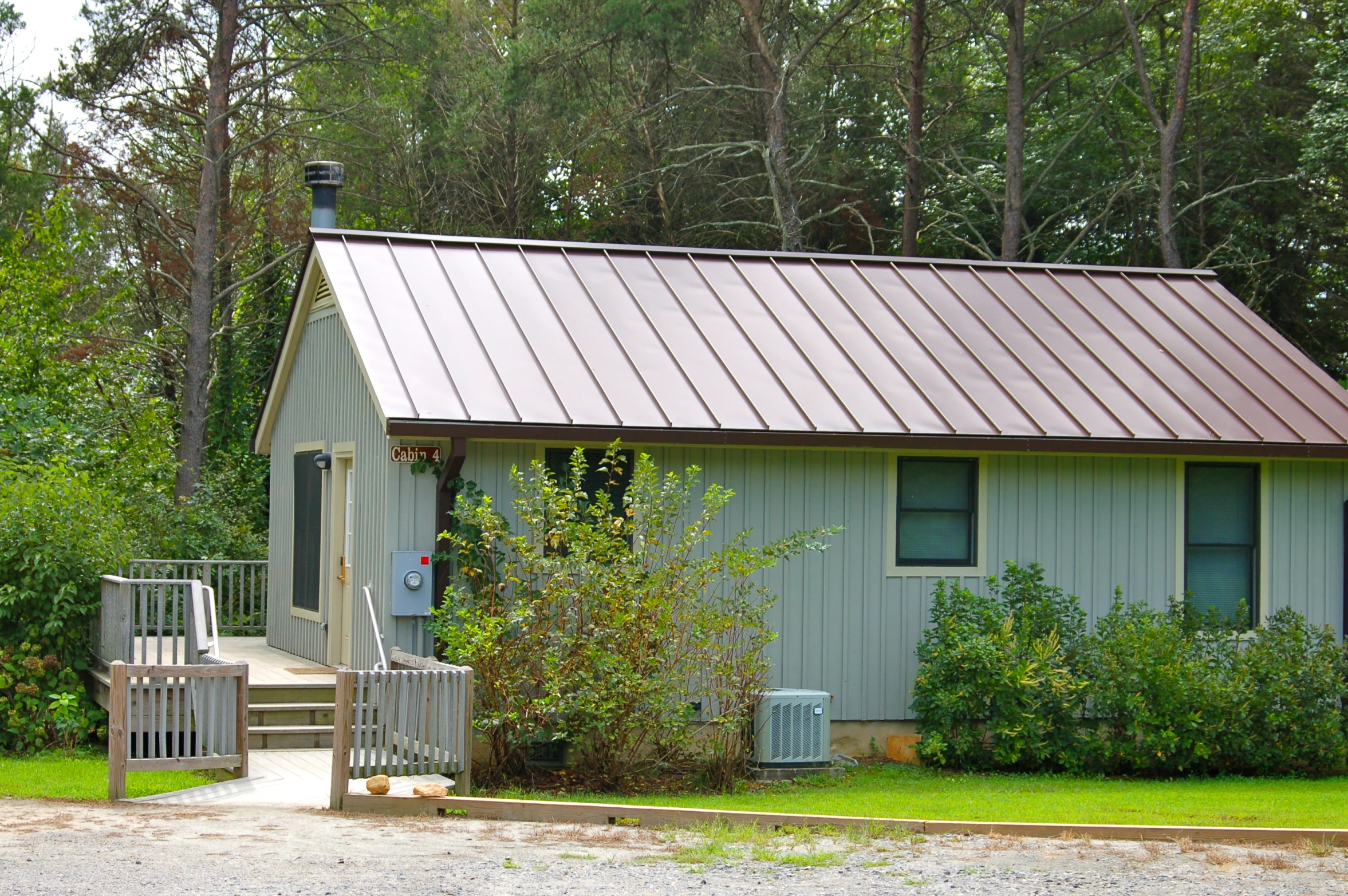 a tiny blue cottage with a roof that is tin and metal