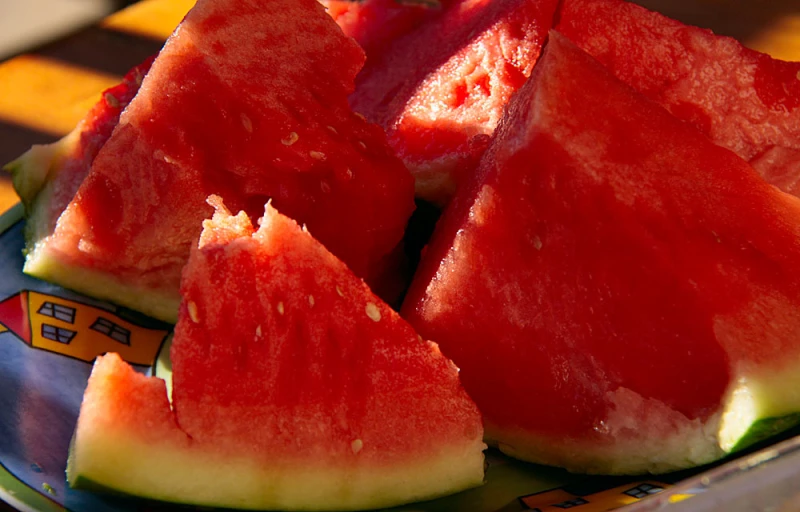 a piece of watermelon is cut in half on a plate