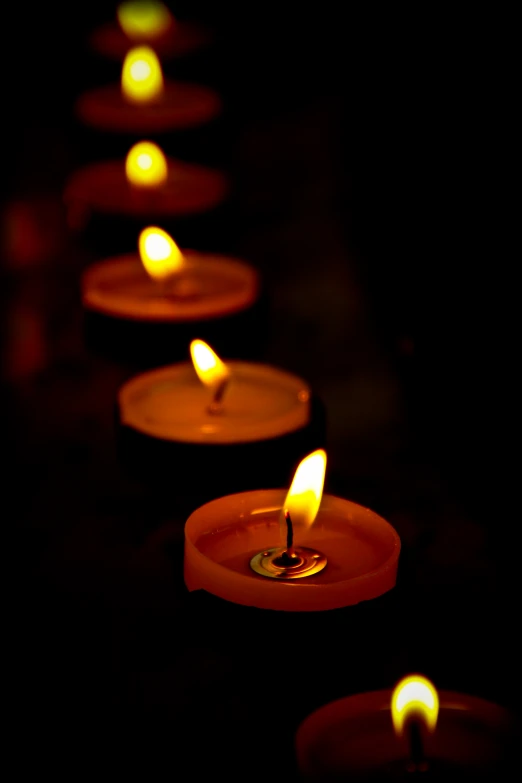 several lit candles in different positions lit at night
