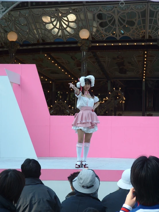 a woman in white and pink on a stage