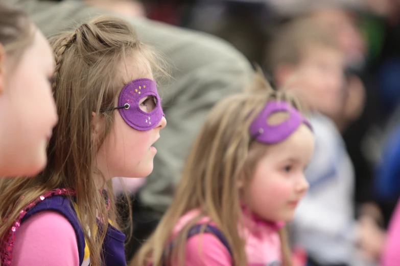 little girls wearing masks in front of an audience