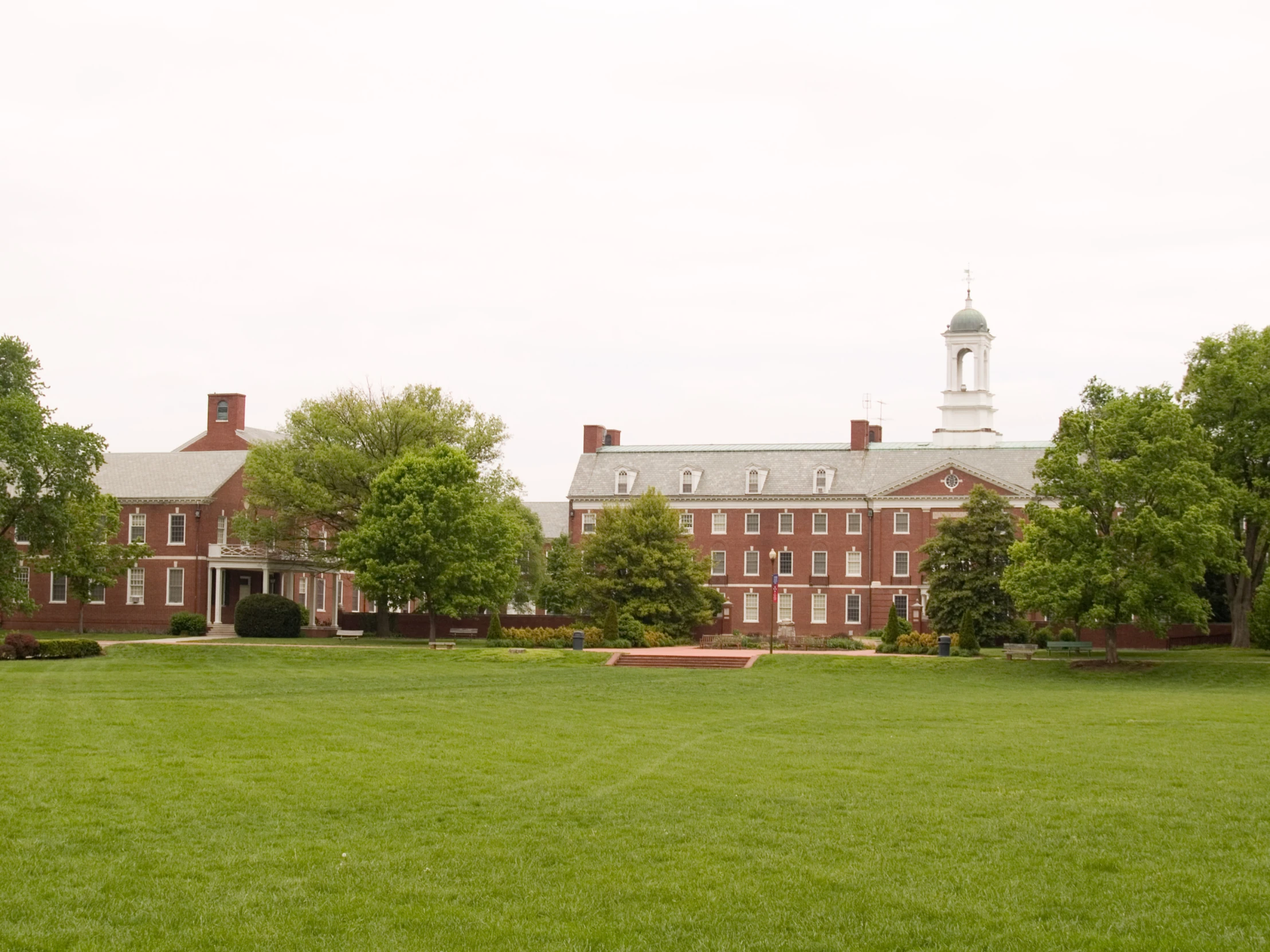 a red brick building surrounded by green grass