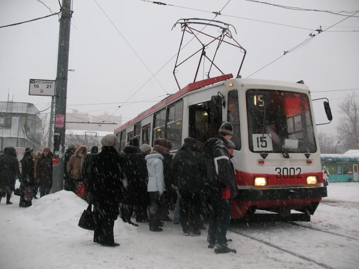 people standing around the passenger train that's pulling into the station