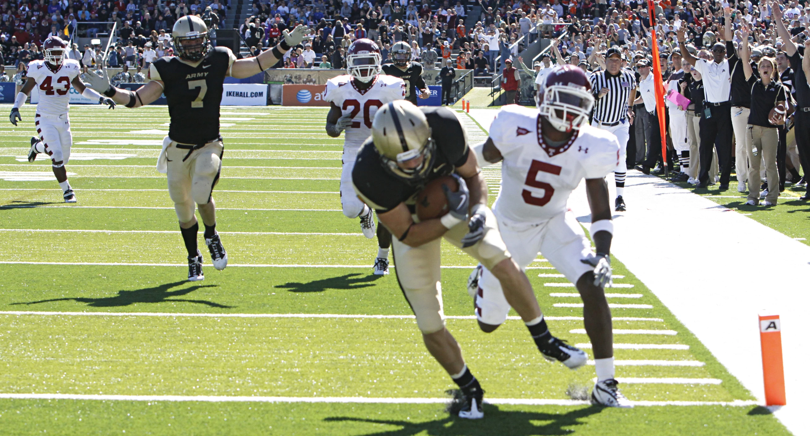 two football players running through the air and wearing uniforms