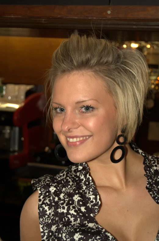 a woman posing for a camera wearing some black hoop earrings