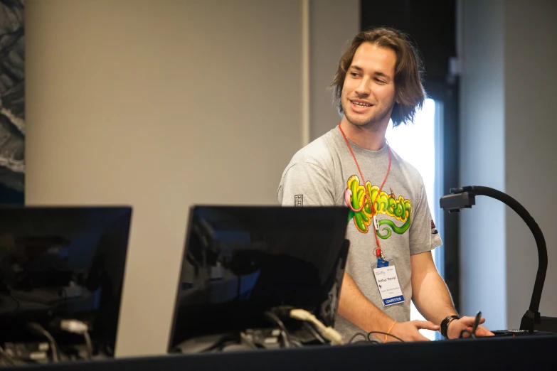 a man is standing in front of some computer screens