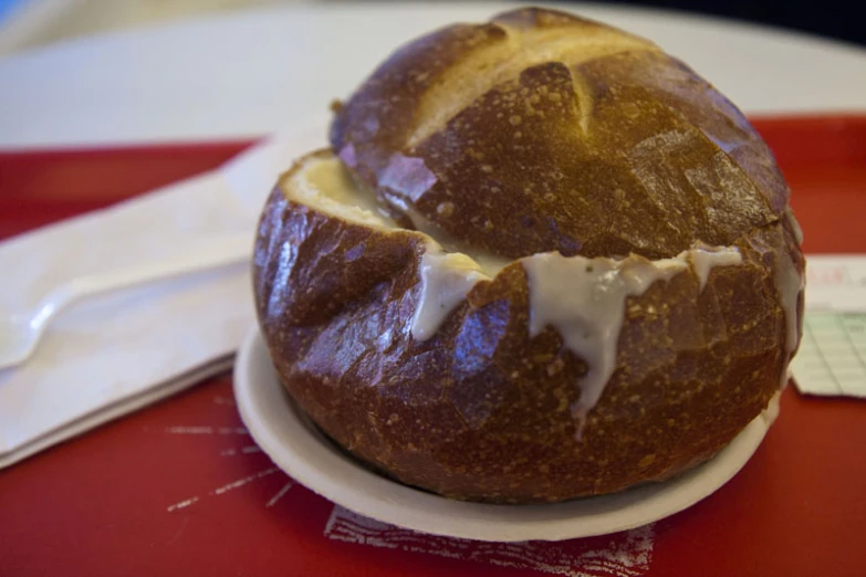 a bread loaf sitting on a plate with a knife and fork