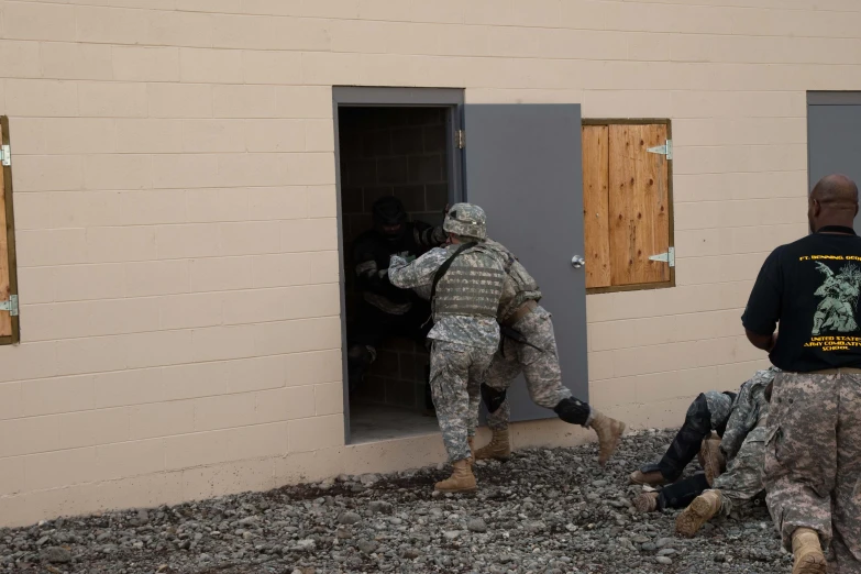 two soldiers that are exiting an building and using a small door