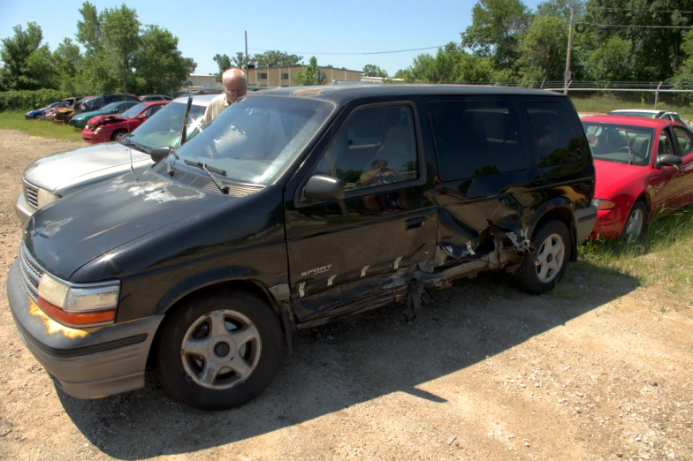 a man looking at the damage on his truck