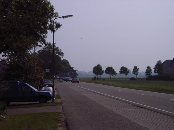 cars parked along side the road on a foggy day