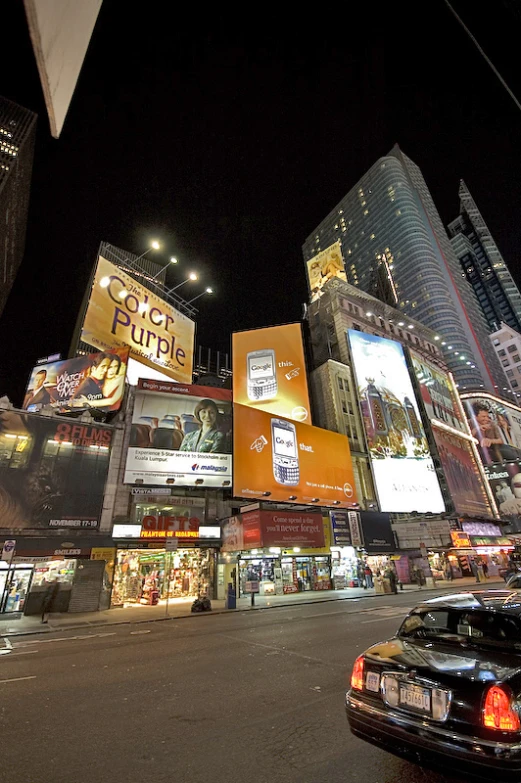 a busy city street at night with lots of tall buildings