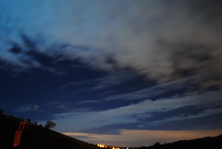 the sky above some hills and street lights