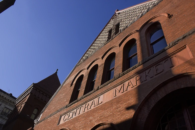 looking up at a brick building with large arched windows