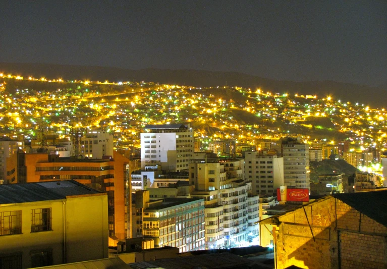 night view of cityscape with lights on the mountain in the background