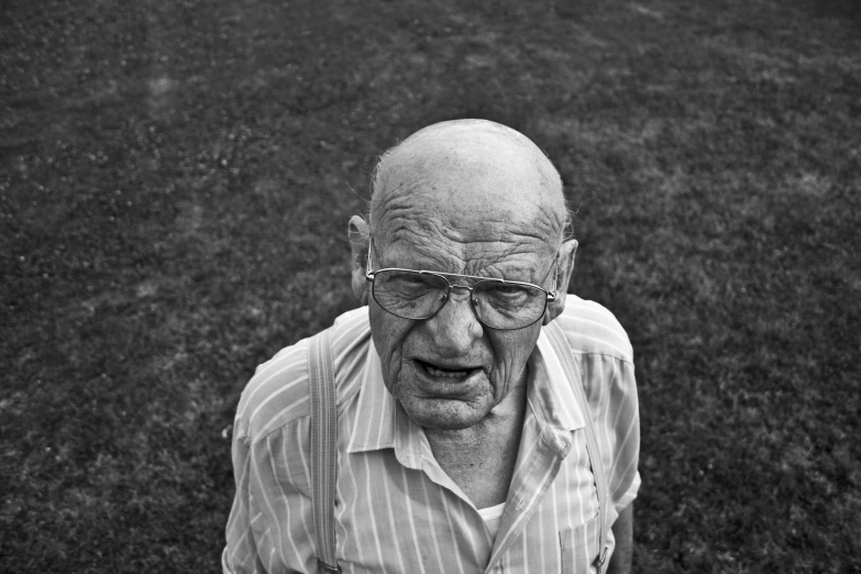 black and white po of an older man standing in front of grass