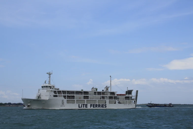 large white boat heading towards shore of the ocean