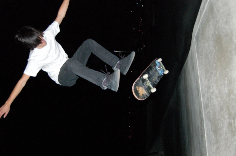 man doing a jump on his skateboard at night