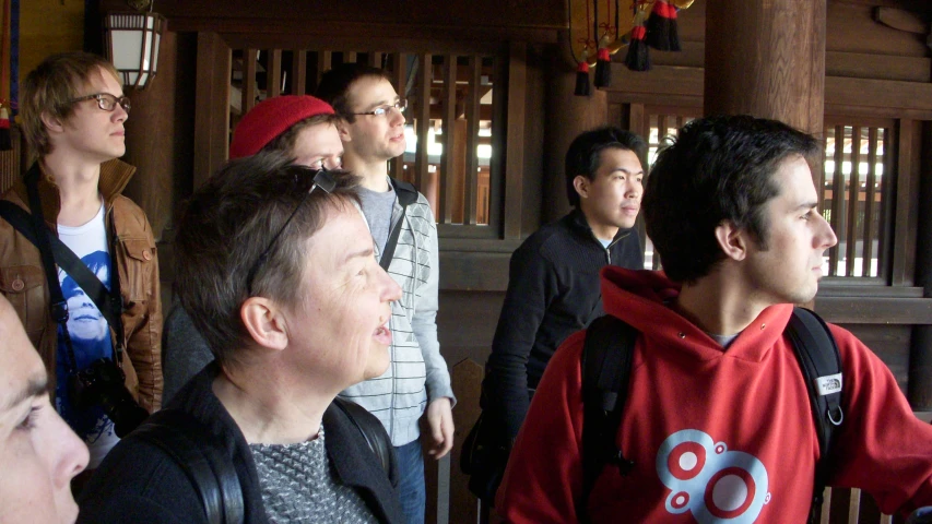 men stand around near an archway in a wood building