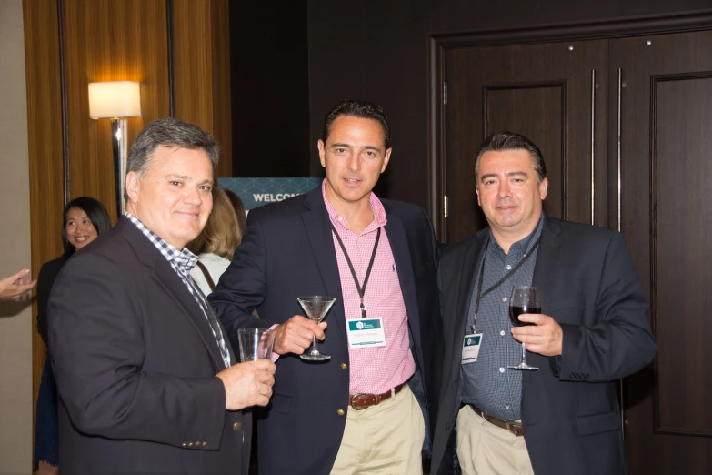 three men wearing suits pose for a picture