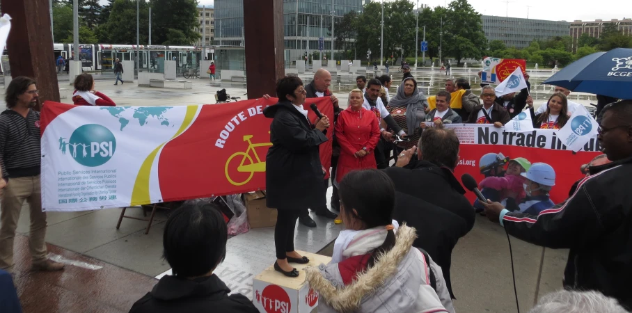 group of people holding large banners in front of a city plaza