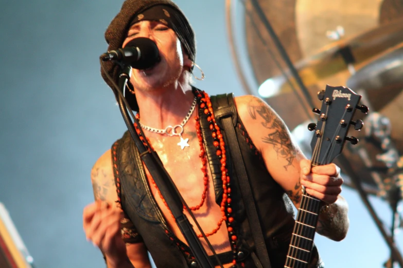 a man in black shirt playing guitar and microphone