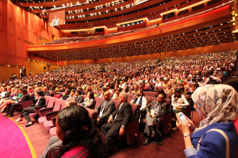 a large audience is seated at the conference